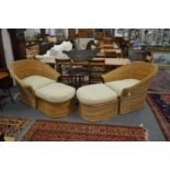 A pair of large wicker armchairs with matching foot stools.