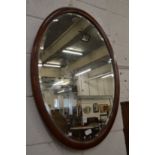 A mahogany framed oval mirror.