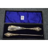 A cased pair of silver handled shoe horn and button hooks.