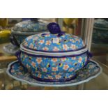 A colourfully decorated French pottery tureen cover and stand.