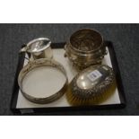 A silver oval mustard pot, lacking liner, an embossed silver bottle coaster frame, a silver backed