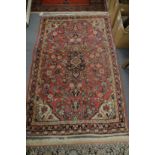 A Persian rug, pink ground with floral decoration 168cm x 103cm.