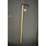 A segmented bone walking stick with horn handle.