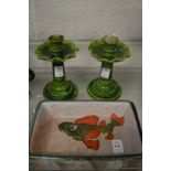 A fish decorated pottery dish and pair of green glazed candlesticks.