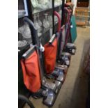 Four Kirby vacuum cleaners with numerous accessories.