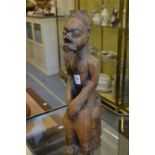 An unusual tribal carved wood seated male figure.