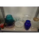 A shelf of colourful and other glassware.