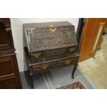 An 18th century carved oak bureau on stand.