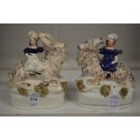 A pair of Staffordshire figures of girls on goats.
