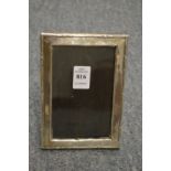 A rectangular silver photograph frame with reeded border.
