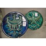 A pair of circular impressed pottery plaques of eagles with turquoise glazed decoration.