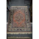 A pink ground Indian rug, the border decorated with elephants 140cm x 100cm.