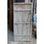 A rustic old pine door with wrought iron fittings.