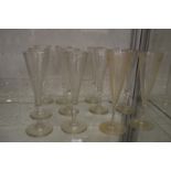 A set of ten cut glass champagne flutes together with a pair of etched champagne flutes.