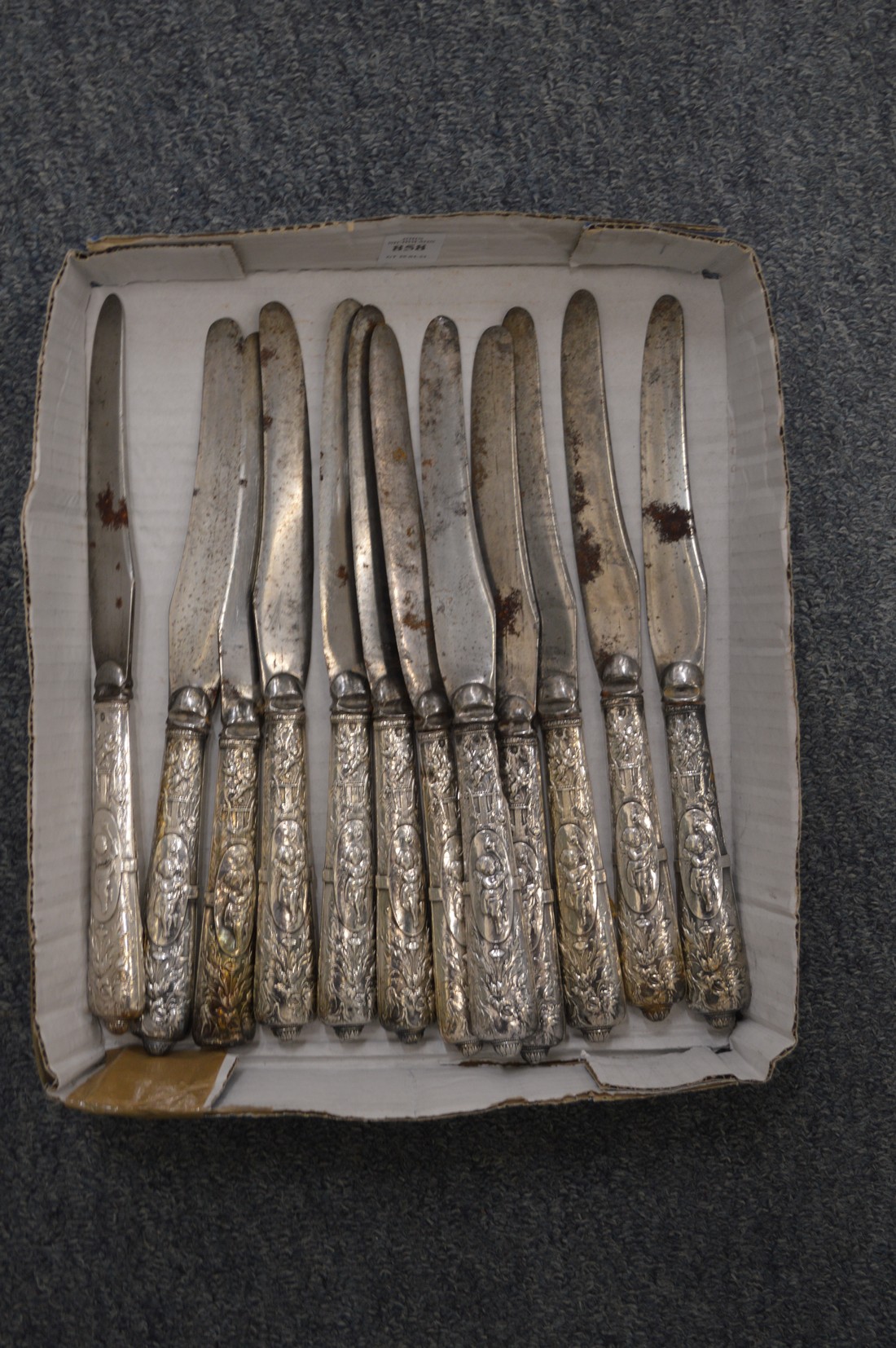 A set of twelve steel bladed knives with embossed handles.
