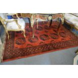 A large Bokhara style carpet, red ground with stylised decoration 233cm x 177cm.