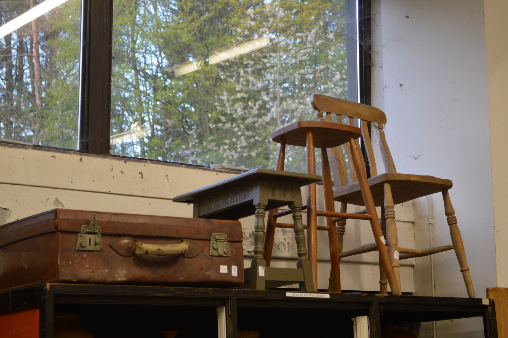 An old leather suitcase, two stools and a chair.