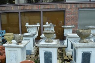 Four various composite garden pedestal planters.