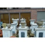 Four various composite garden pedestal planters.