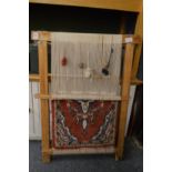 A Persian carpet demonstration loom with part made rug.