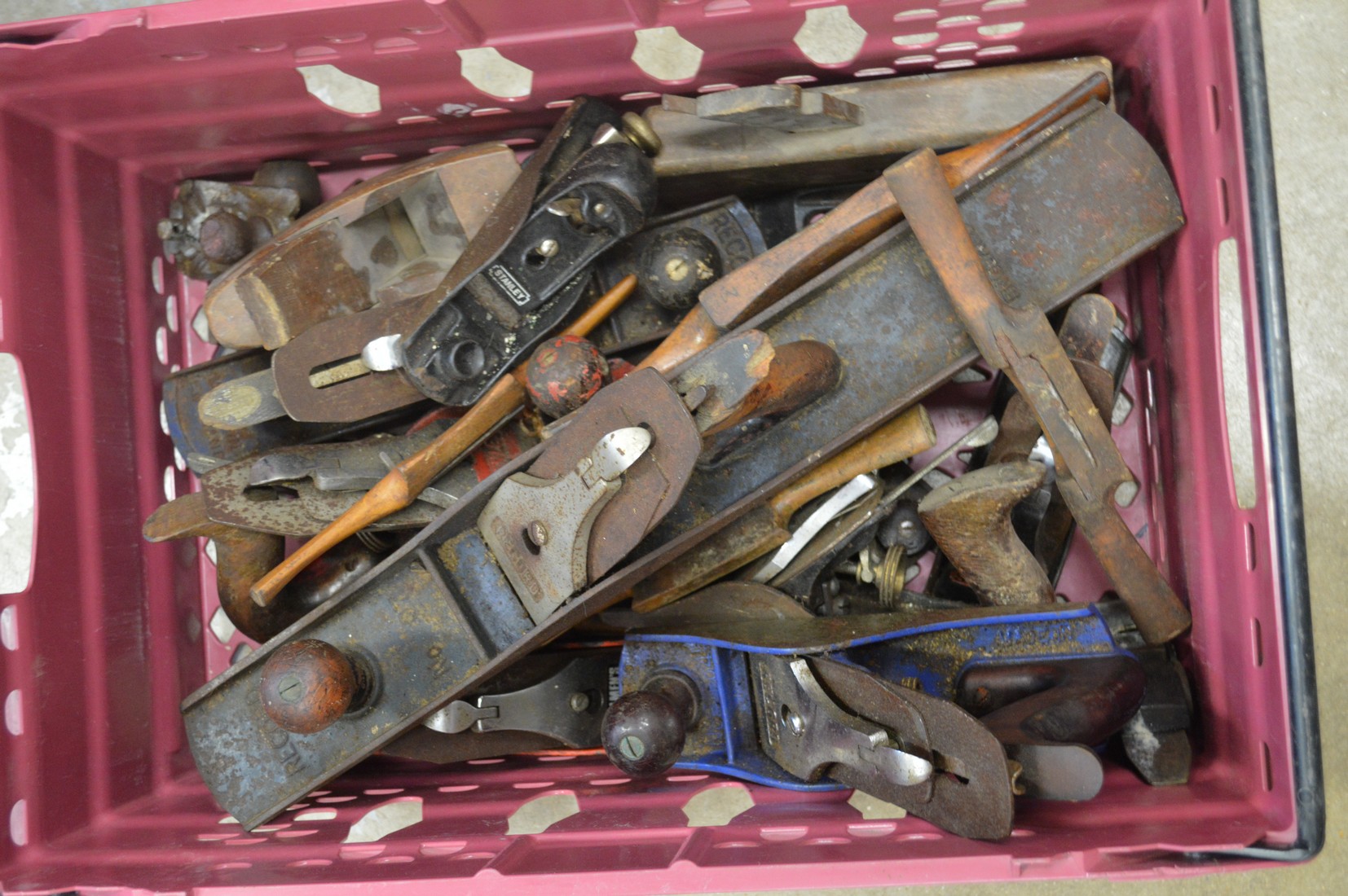 A box of wood working planes and spokeshaves.