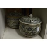 Two similar Oriental blue and white pottery bowls and covers.
