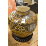 A Korean pottery jar and cover on hardwood stand.