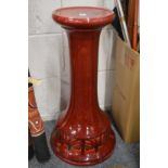 A Bretby red glazed pottery jardiniere stand.
