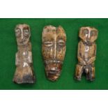Three carved bone figures/masks.