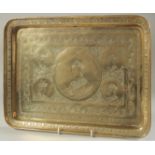 A 19TH CENTURY PERSIAN QAJAR BRASS TRAY, with engraved portraits, 37cm x 27cm.