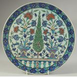 A 19TH CENTURY KUTAHYA GLAZED POTTERY PLATE, painted with sprays of flora, 29.5cm diameter.