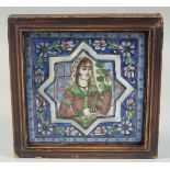 A FRAMED PERSIAN QAJAR GLAZED POTTERY TILE, central star portrait panel and foliate border, 20cm