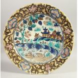 A RARE AND UNUSUAL PERSIAN - CHINESE MARKET GLAZED POTTERY DISH, 30cm diameter.