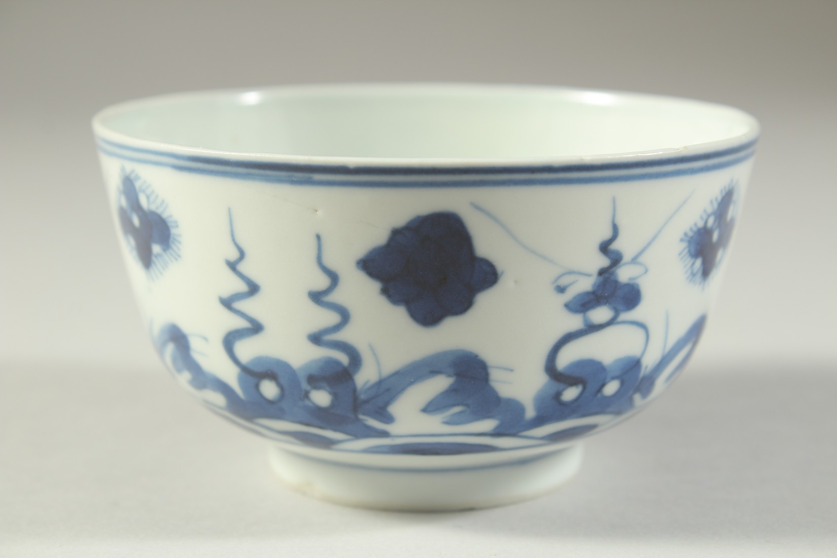 A SMALL 19TH CENTURY CHINESE BLUE AND WHITE PORCELAIN BOWL, painted with stylised waves and floral - Image 2 of 5