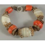 A MIDDLE EASTERN BRACELET CONTAINING ANCIENT AGATE BEADS AND LARGE CORAL BEADS.