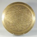 A LARGE ISLAMIC ENGRAVED BRASS TRAY, with central inscription, 70cm diameter.