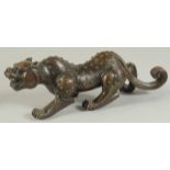 A FINE CHINESE BRONZE FIGURE OF A TIGER, with raised spotted pattern to the body, 26cm long.
