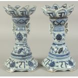 A PAIR OF CHINESE BLUE AND WHITE PORCELAIN LOTUS CANDLESTICKS, 26cm high.