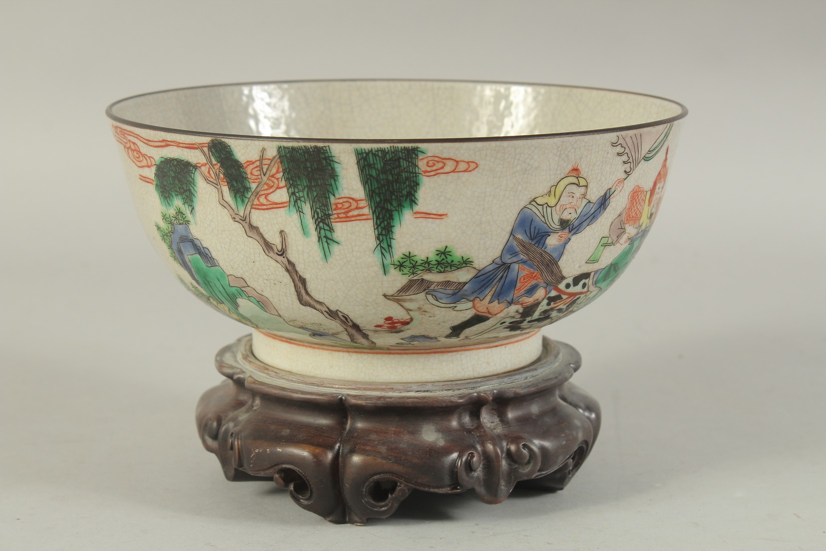 A CHINESE FAMILLE VERTE PORCELAIN BOWL - possibly Qing dynasty, with hardwood stand, the exterior