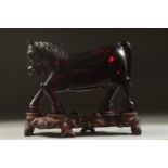 A RARE CHINESE BAKELITE -POSSIBLY CHERRY AMBER HORSE on original wooden stand, horse 21cm long,