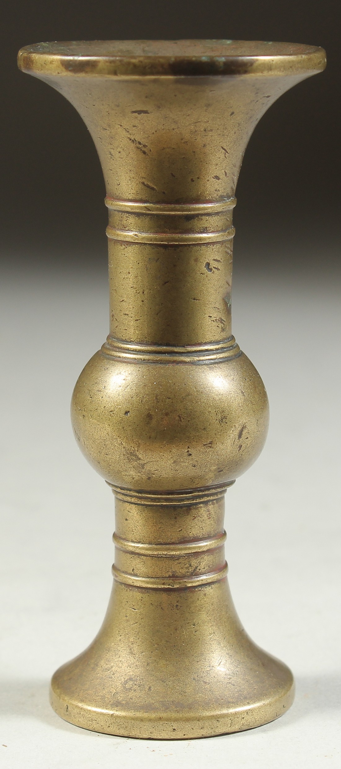 A SMALL CHINESE BRASS GU SHAPE VASE, 10cm high.