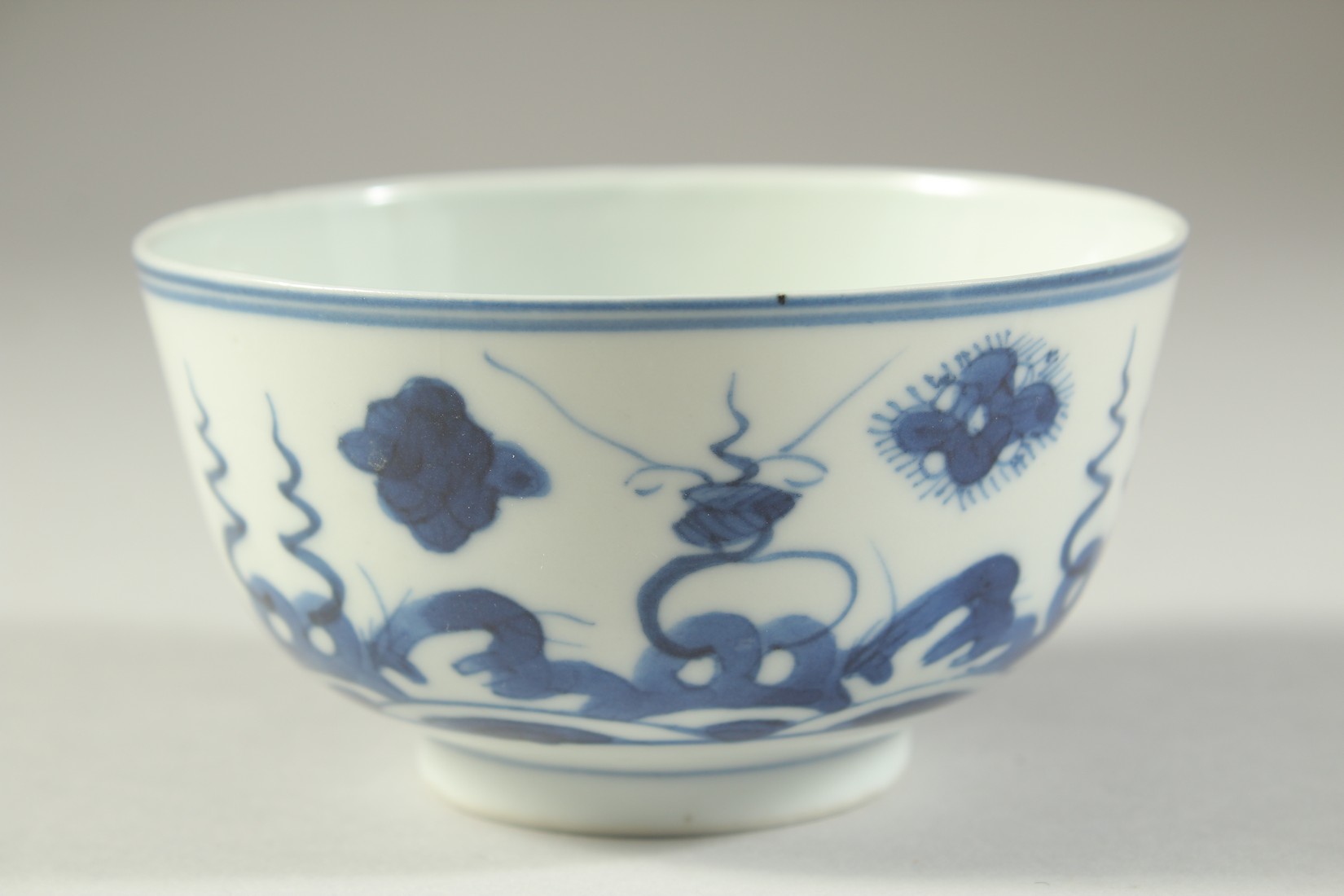 A SMALL 19TH CENTURY CHINESE BLUE AND WHITE PORCELAIN BOWL, painted with stylised waves and floral - Image 3 of 5