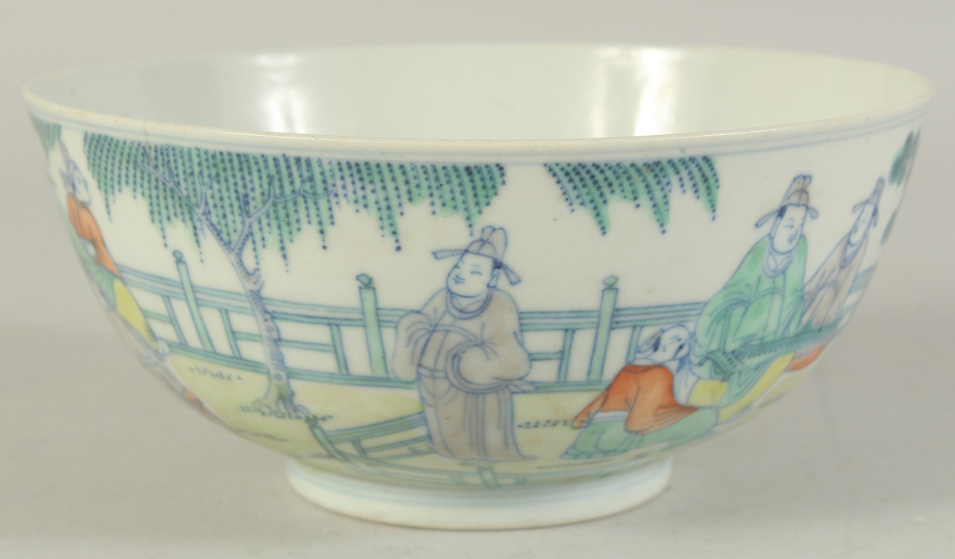 AN 19TH CENTURY CHINESE PORCELAIN BOWL, painted with various figures in an outdoor setting, the base