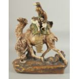 AN AMPHORA PORCELAIN GROUP OF A CAMEL AND RIDER, the camel being attacked by a lion, 38.5cm high.