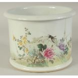 A CHINESE FAMILLE ROSE PORCELAIN BRUSH POT, painted with a cricket and flora, the base with red