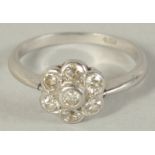 A PLATINUM AND DIAMOND FLOWER HEAD CLUSTER RING.