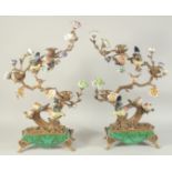 A GOOD PAIR OF PORCELAIN BIRDS on a tree, with scrolling branch and three candle holders. 24ins
