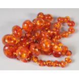 A GOOD FACETED AMBER GRADUATED NECKLACE, 56beads, 24ins long, 40gms.