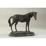 A BRONZE STANDING HORSE. 10ins long, on a marble base.