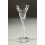 AN 18TH CENTURY ENGLISH WINE GLASS with inverted bell bowl and air twist stem, with a knop. 5.5ins